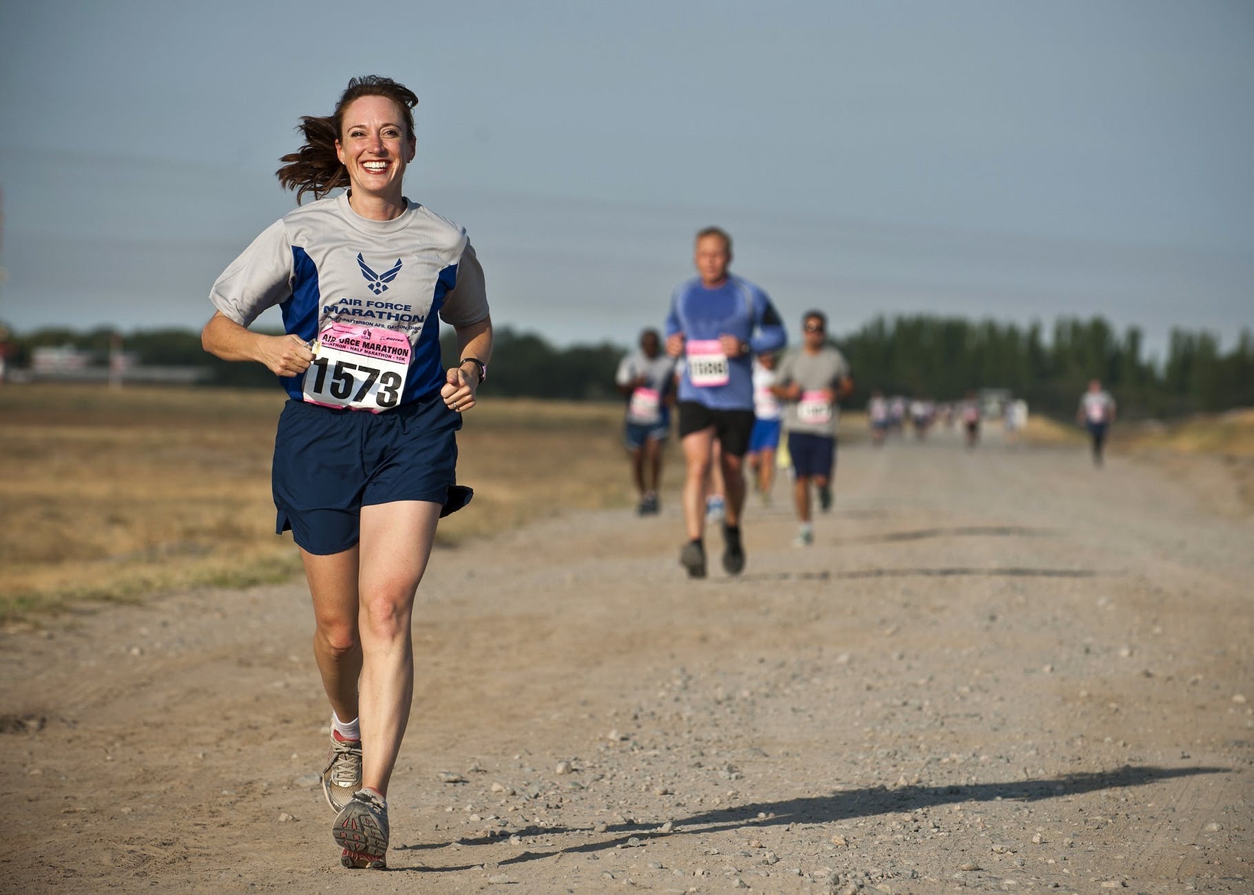 woman in gray crew neck shirt running on brown soil during daytime